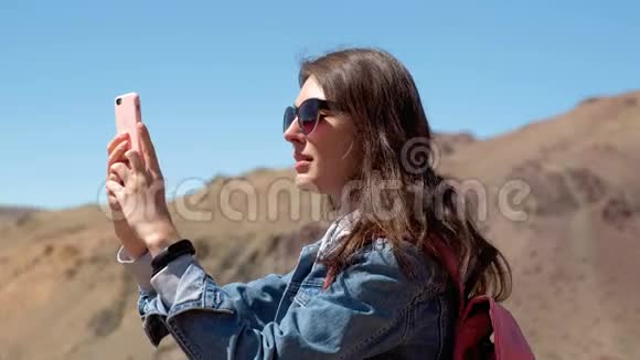 太阳镜和粉红色背包的Brunette拍摄了一张4k河的春天峡谷的照片视频的预览图