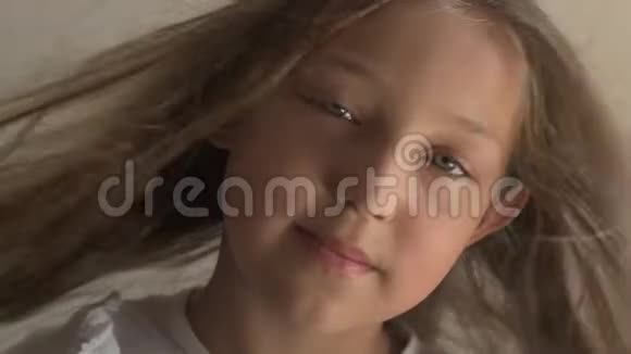 蓝色眼睛和金色头发的快乐少女的特写肖像站在风上微风在玩弄女孩的头发暴风雨视频的预览图