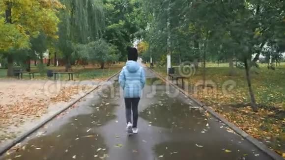 雨天在秋天公园散步的漂亮女孩视频的预览图