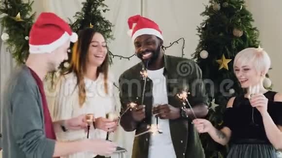 不同种族的年轻美丽的人在圣诞树旁边跳舞很有趣朋友们庆祝视频的预览图