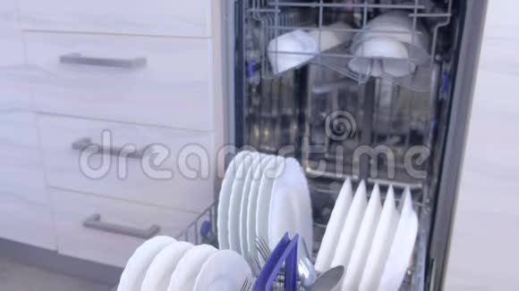 清洁厨房内置洗碗机篮子中的白色盘子和餐具视频的预览图