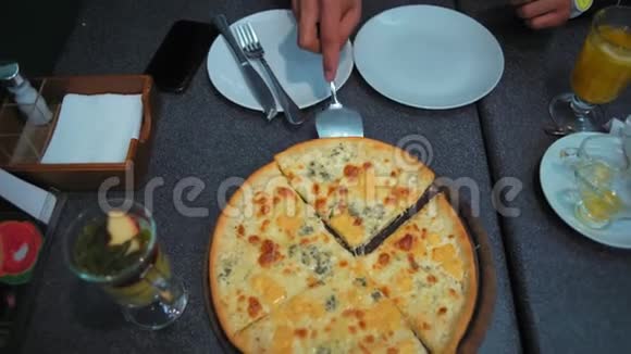 特写镜头男人手把切好的披萨放在盘子里视频的预览图