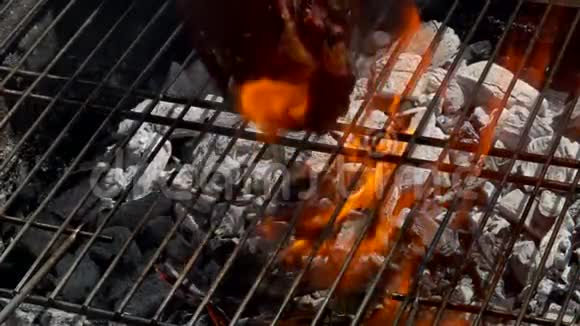 厨师用火钳在烤架上转动牛排视频的预览图