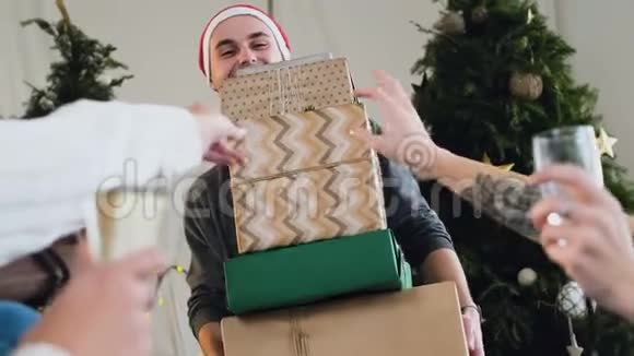 圣诞前夜圣诞老人戴着圣诞帽的快乐快乐的家伙正为他亲爱的朋友和女朋友捧着许多礼物盒视频的预览图