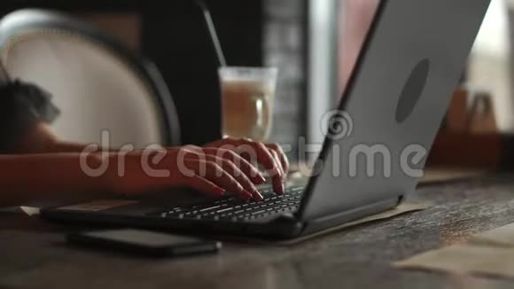手持电话指着笔记本电脑背景上的空屏幕的女人护照钱包在工艺桌上顶部视频的预览图