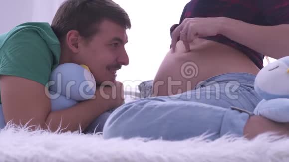 幸福男人看着肚子里的孕妻笑着凑了上去两人用手指模仿舞步视频的预览图
