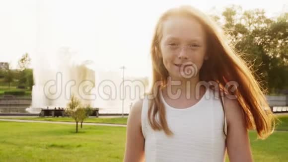 快乐的小红发女孩雀斑在阳光下漫步在夏日公园视频的预览图