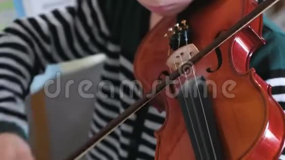 无法辨认的男孩正在学习拉小提琴视频的预览图