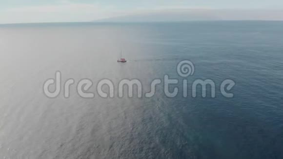 空中射击在蔚蓝的海水中孤独的帆船对着蓝天积极的概念视频的预览图