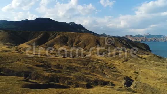 蓝色海岸附近黄干丘陵山区景观鸟瞰图射击秋季自然视频的预览图