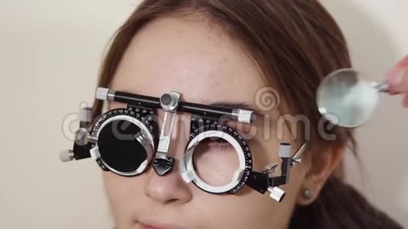 近距离拍摄一个眼睛检查视力的女人的脸视频的预览图