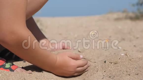 孩子们在海滩上抛沙孩子们双手舀起一把沙子举到上面从他的手里倒出来视频的预览图
