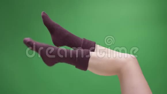 可爱的小红短袜中的少女美腿特写镜头玩味地移动背部被隔离在绿色上视频的预览图