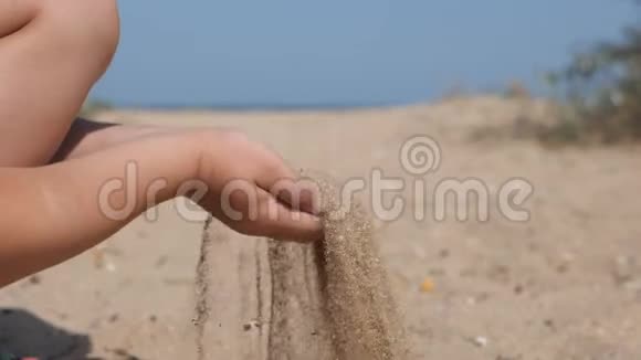 孩子们在海滩上抛沙孩子们双手舀起一把沙子举到上面从他的手里倒出来视频的预览图