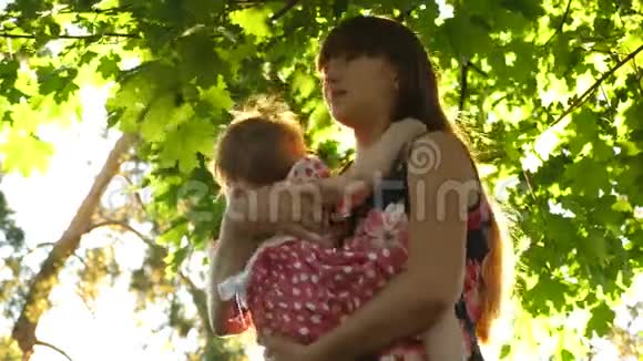 年轻妈妈拥抱小女儿亲吻和微笑视频的预览图
