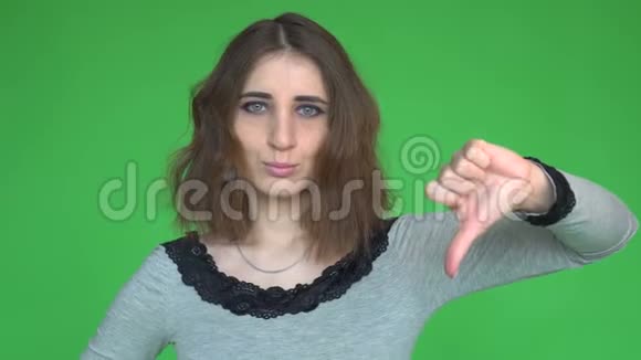 年轻女子伸出大拇指在可移动的色度键背景下拍摄视频的预览图