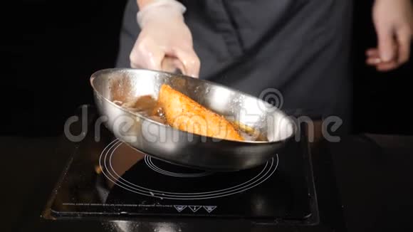 不健康的脂肪食品观念煎鲑鱼鳟鱼鲑鱼鱼片皮侧向下的平底锅炸红鱼片视频的预览图
