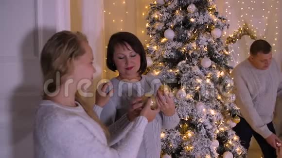 幸福的家庭在舒适的客厅装饰圣诞树圣诞节的心情视频的预览图