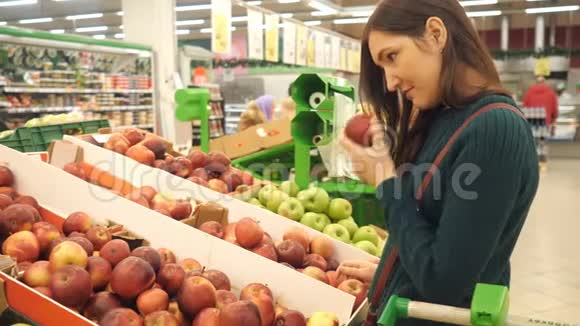 有魅力的年轻女性选择水果蔬菜超市市场上的苹果视频的预览图