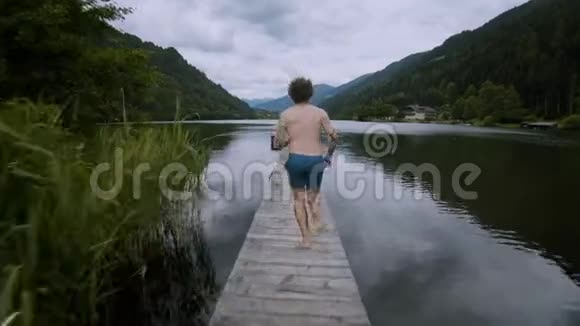 年轻人跑着跳进高山湖泊里视频的预览图
