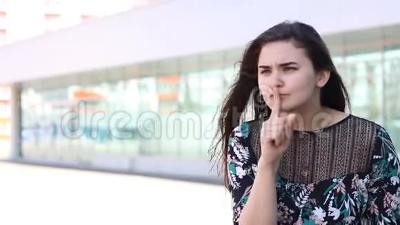 当她要求沉默时女人做了一个嘘声的手势把手指举到嘴唇上视频的预览图