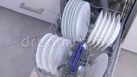 清洁厨房内置洗碗机篮子中的白色盘子和餐具视频的预览图