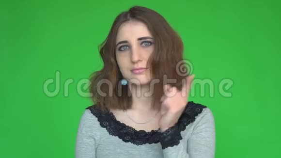 一个严肃的年轻女人的肖像用手指在绿色背景上显示停止的手势视频的预览图