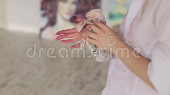 一个艺术家女孩用抹布擦手的特写镜头视频的预览图