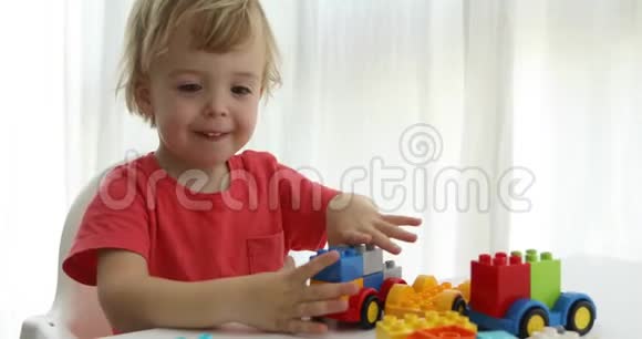 特写幼儿双手玩彩色塑料砖视频的预览图
