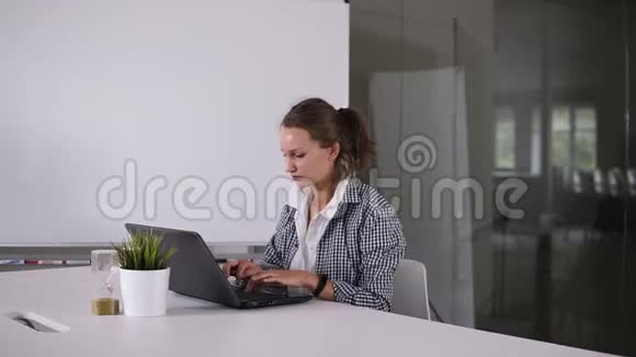 扎马尾辫的女孩在现代阁楼工作室使用笔记本电脑研究过程工作年轻的商业女性视频的预览图