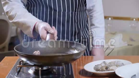 出去吃饭准备食物厨师端着一个锅盛着沸油和大蒜慢动作油溅视频的预览图