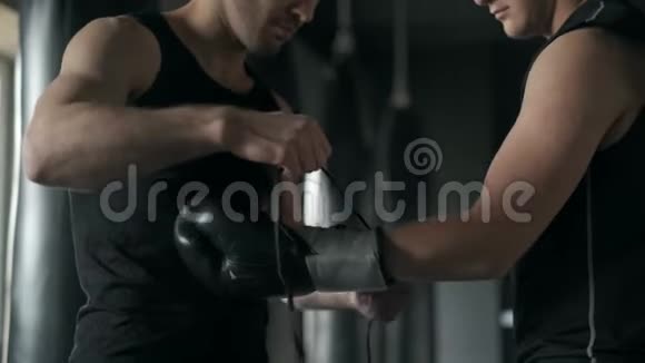 训练员在训练前给运动员戴上拳击手套4K慢动作视频的预览图