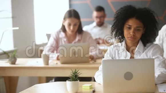 非裔美国女商人在同事中使用带有图形的笔记本电脑视频的预览图