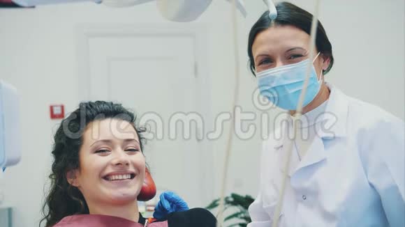 很好的专家一位穿着晨衣和口罩的漂亮年轻女牙医的肖像给一个牙医视频的预览图