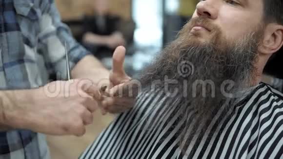 理发师和留着长胡子的成年男子理发店理发梳胡子美容师视频的预览图