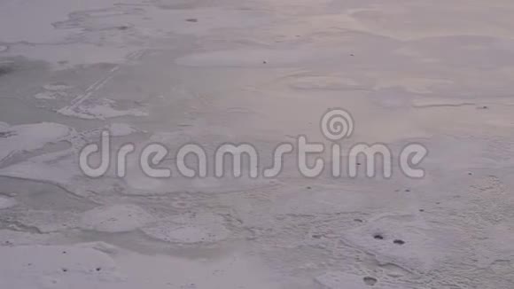 一条覆盖着雪的冰冻河流的特写上面有脚印视频的预览图