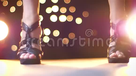 拍摄黑色的黑色高跟鞋在妇女的腿与爆发从射击彩色的光点上视频的预览图