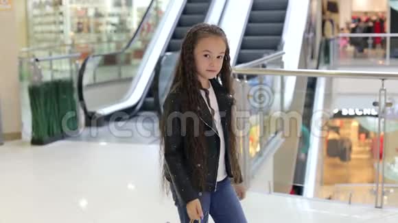 一个可爱的小女孩在购物中心的画像用拇指向上的包裹视频的预览图