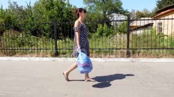 一个戴太阳镜的漂亮女孩手里拿着一包垃圾扔垃圾夏日炎炎视频的预览图