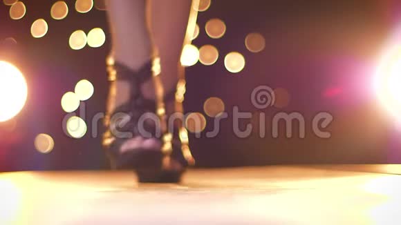 华丽的双脚踩在黑色时尚高跟鞋上向镜头移动站立变换姿势明亮的背景视频的预览图