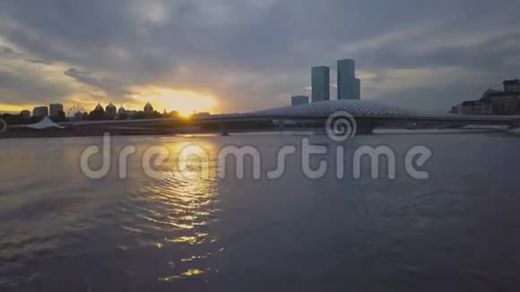 日落在城市上空游客们沿着河上的柱子走阿斯塔纳视频的预览图