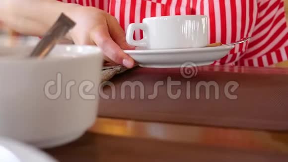 女人把糖立方体放进茶杯里咖啡店女人手拿着茶杯把糖块捡起来视频的预览图
