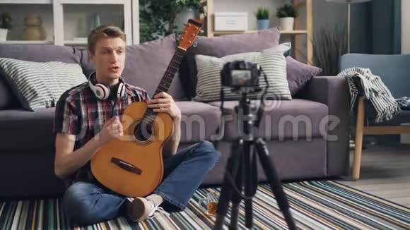 专业的音乐家博主正在录制关于使用相机为网络博客演奏吉他的教程他在说话视频的预览图