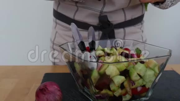 在餐桌上的玻璃碗中加入蔬菜沙拉视频的预览图