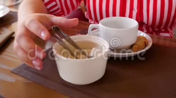 女人把糖立方体放进茶杯里咖啡店女人手拿着茶杯把糖块捡起来视频的预览图