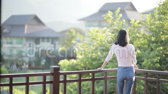 在家庭露台放松年轻的亚洲女人视频的预览图