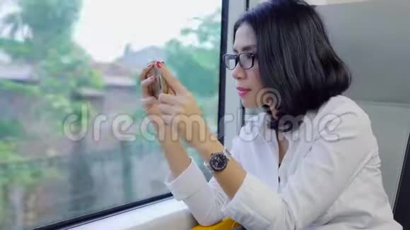 女人在火车上用手机录制视频视频的预览图
