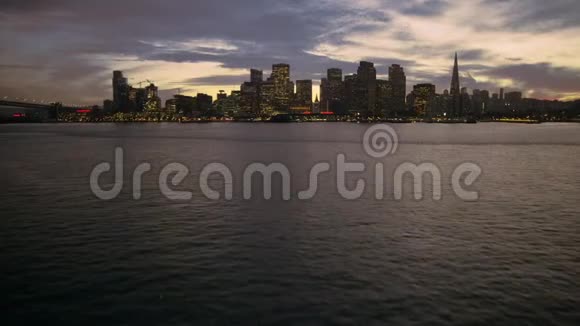 低角度空中日落飞行在平静的海水旧金山现代市中心摩天大楼城市景观天际线视频的预览图