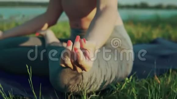日落时分女人的手在莲花的位置晚上在湖边做瑜伽的女孩视频的预览图