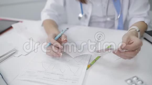 一位女医生检查她的病人心电图诊所的医务处在接待处的一个年轻女孩视频的预览图